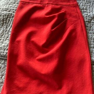Fully lined red pencil skirt with golden buttons and darts on the back